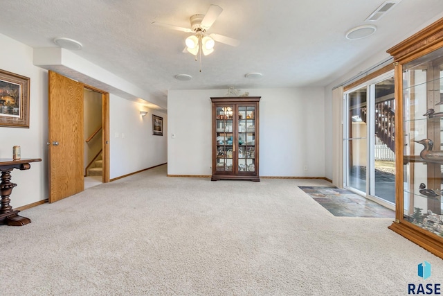 interior space with ceiling fan and a textured ceiling