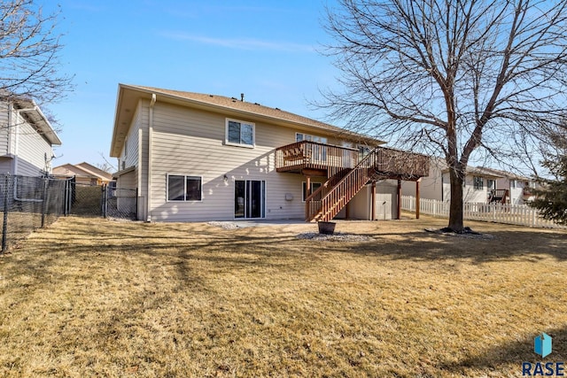 rear view of house featuring a wooden deck and a yard