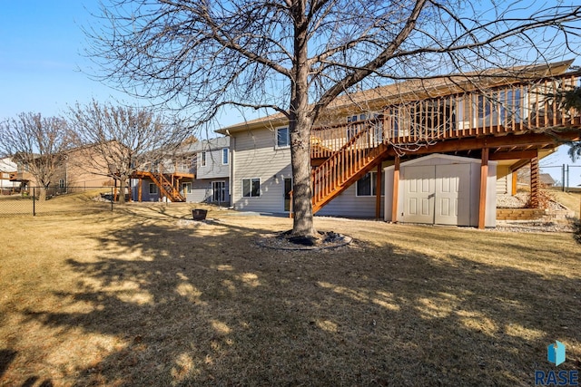 back of house featuring a wooden deck, a yard, and a storage shed