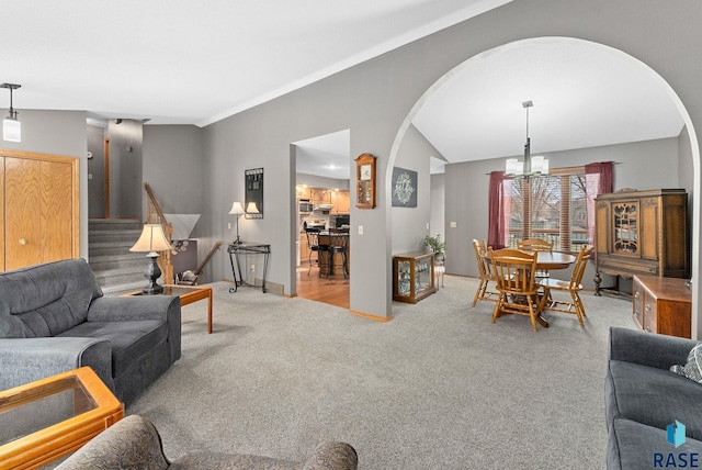 carpeted living room featuring lofted ceiling and an inviting chandelier