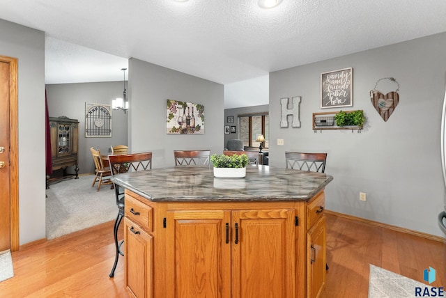 kitchen featuring hanging light fixtures, lofted ceiling, a center island, and a kitchen bar