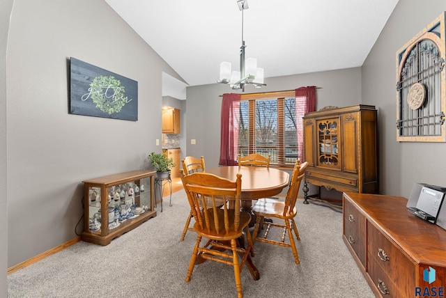 dining area with lofted ceiling, light carpet, and an inviting chandelier