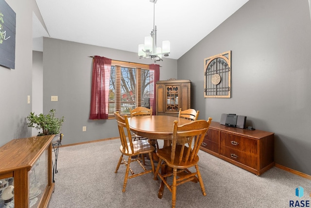 dining area featuring vaulted ceiling, light carpet, and an inviting chandelier