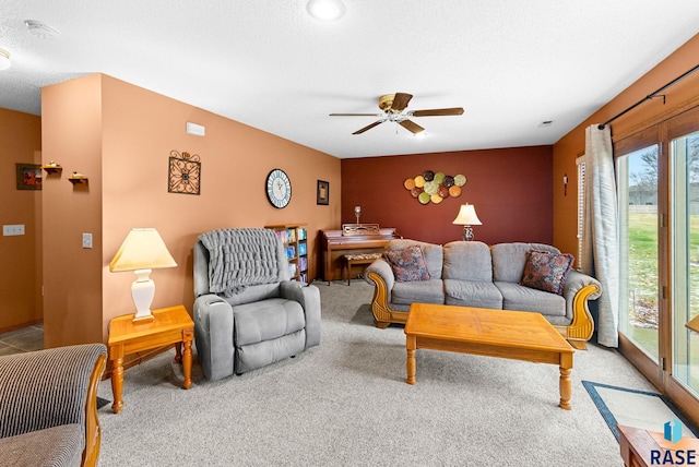 living room featuring carpet, a textured ceiling, and ceiling fan