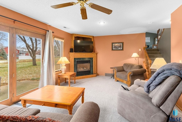 carpeted living room with ceiling fan and a textured ceiling