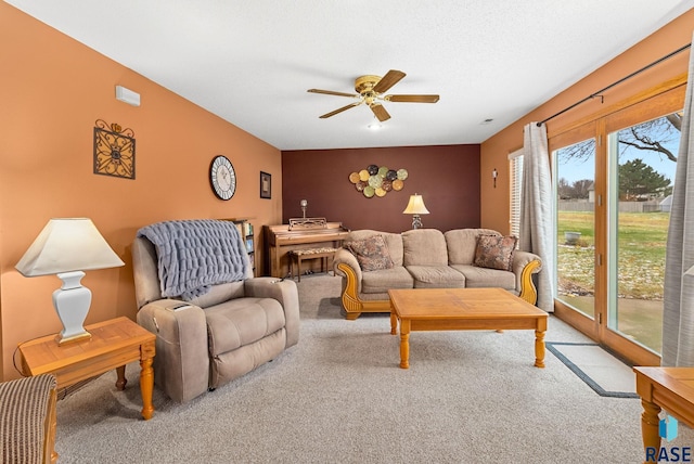 carpeted living room featuring a textured ceiling and ceiling fan