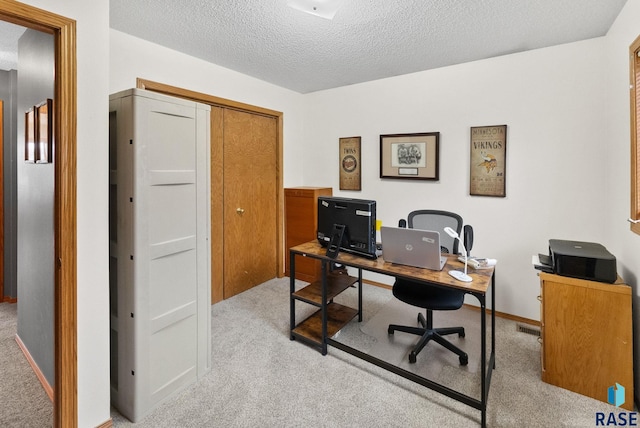 carpeted office with a textured ceiling