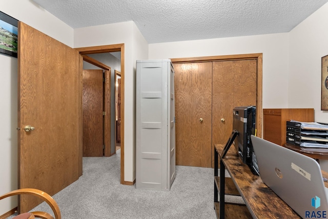 carpeted office space featuring a textured ceiling