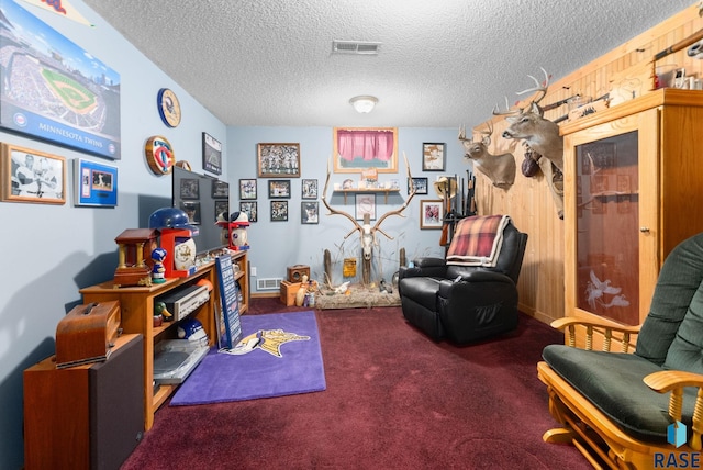 living area featuring dark carpet and a textured ceiling