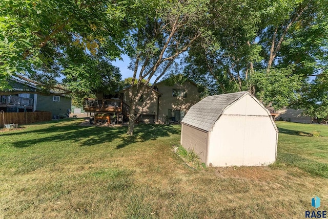 view of yard with a wooden deck and a storage unit