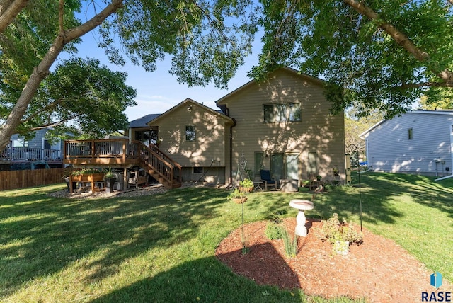 rear view of house featuring a yard and a deck