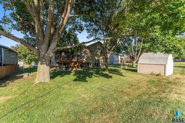 view of yard with a wooden deck and a storage unit