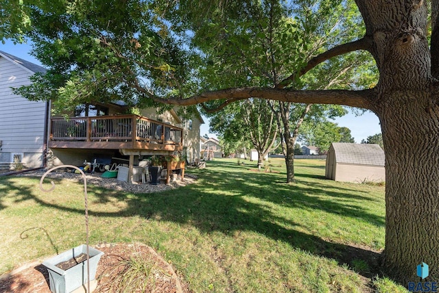 view of yard featuring a wooden deck and a storage unit