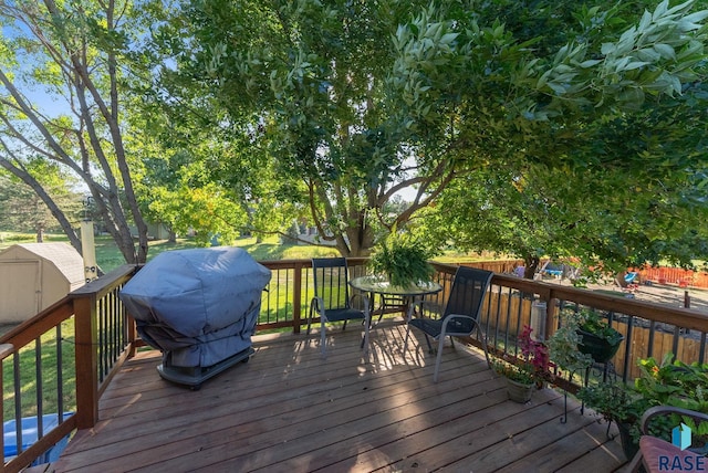 deck with a storage shed and grilling area