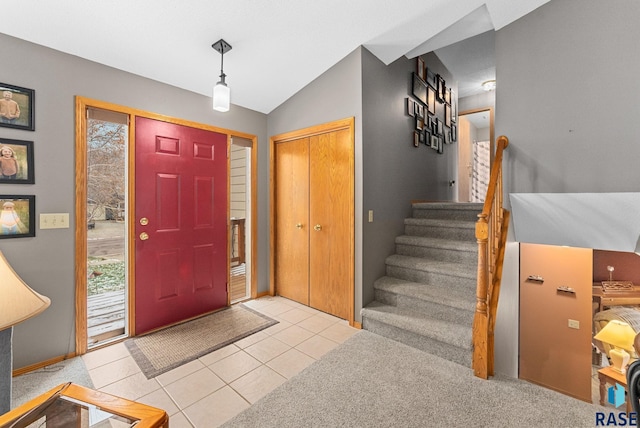 entryway featuring light tile patterned flooring and vaulted ceiling