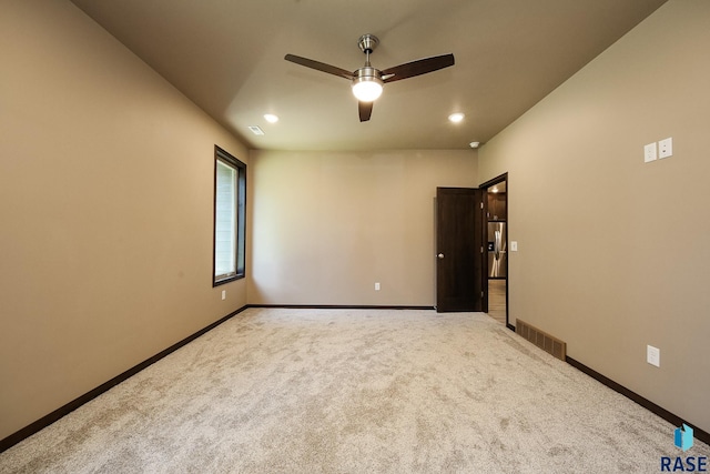 carpeted spare room with ceiling fan