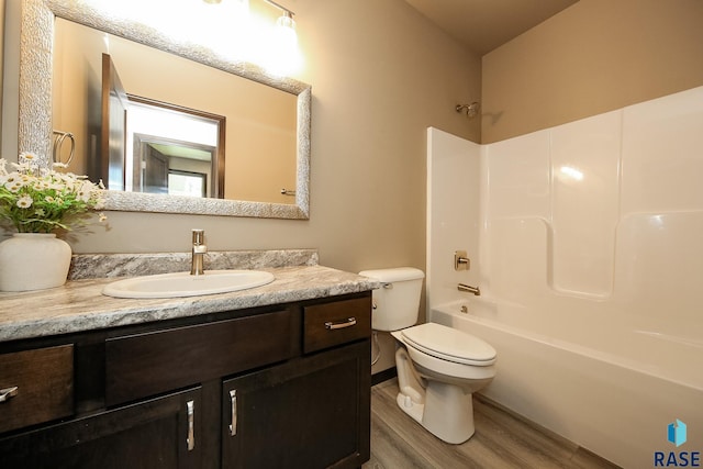 full bathroom with hardwood / wood-style flooring, vanity, shower / bathtub combination, and toilet