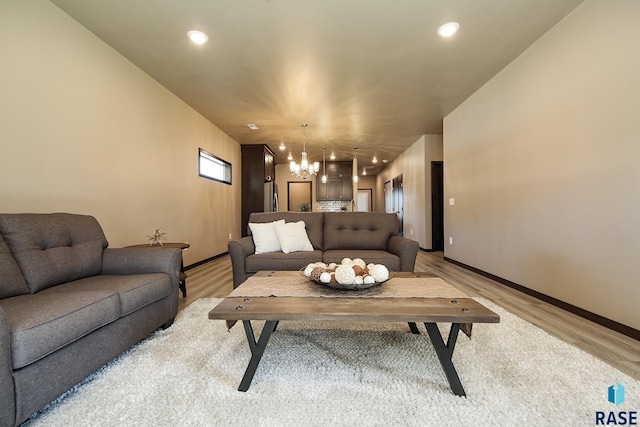 living room featuring an inviting chandelier and light hardwood / wood-style flooring