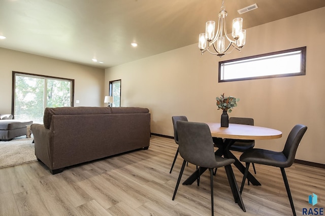 dining room featuring a healthy amount of sunlight, a chandelier, and light hardwood / wood-style floors