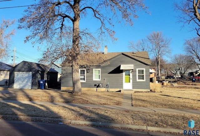 view of front of property featuring a garage and an outdoor structure