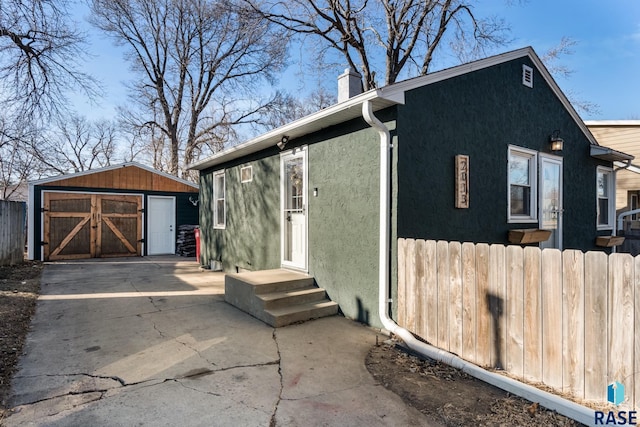 view of home's exterior featuring a garage and an outbuilding