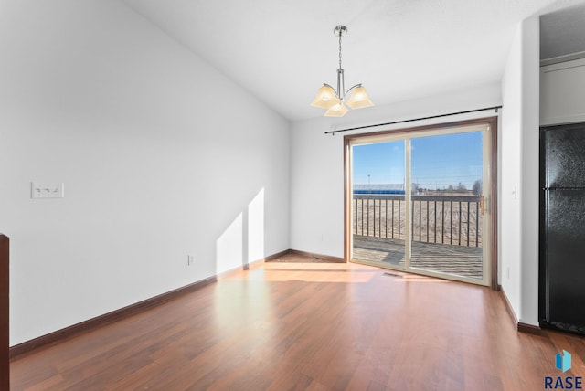 unfurnished dining area with an inviting chandelier, wood-type flooring, and lofted ceiling