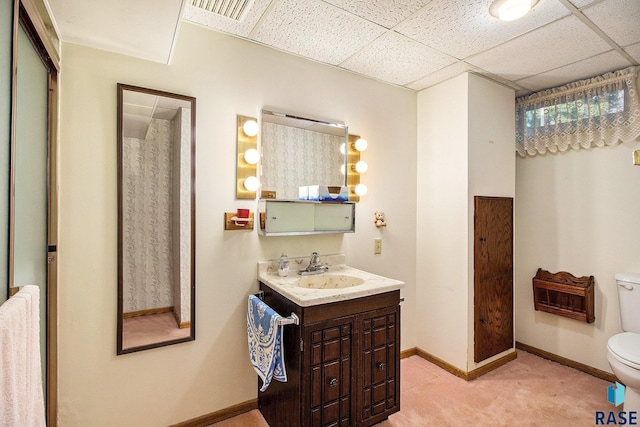 bathroom featuring vanity, a paneled ceiling, and toilet