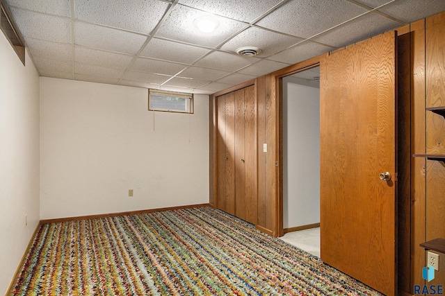 basement with light carpet and a drop ceiling