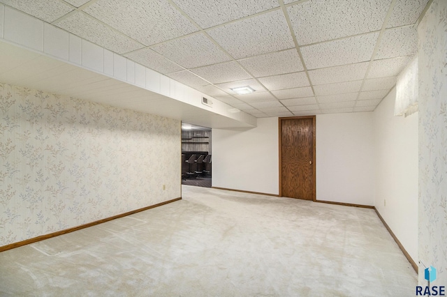 basement featuring a paneled ceiling and carpet floors