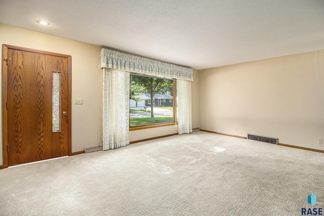 carpeted spare room featuring a textured ceiling