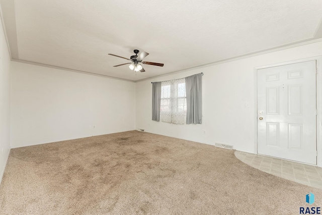 carpeted spare room featuring ceiling fan and a textured ceiling