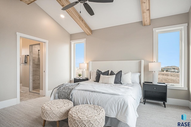 carpeted bedroom featuring ceiling fan, ensuite bath, multiple windows, and vaulted ceiling with beams