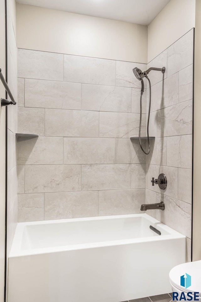 bathroom featuring tiled shower / bath