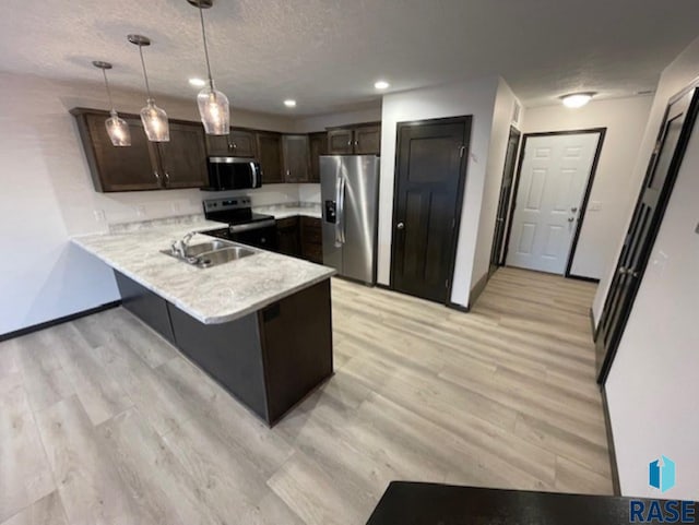 kitchen featuring stainless steel appliances, dark brown cabinetry, decorative light fixtures, kitchen peninsula, and light wood-type flooring