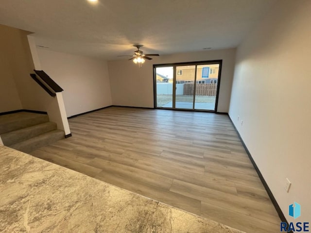 unfurnished living room with ceiling fan and light wood-type flooring