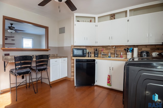 kitchen featuring washer / clothes dryer, sink, white cabinets, and black appliances