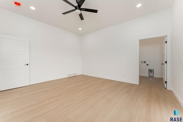 empty room with ceiling fan and light hardwood / wood-style floors