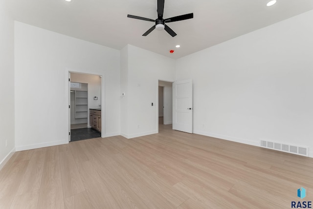 unfurnished bedroom featuring connected bathroom, light hardwood / wood-style floors, and ceiling fan