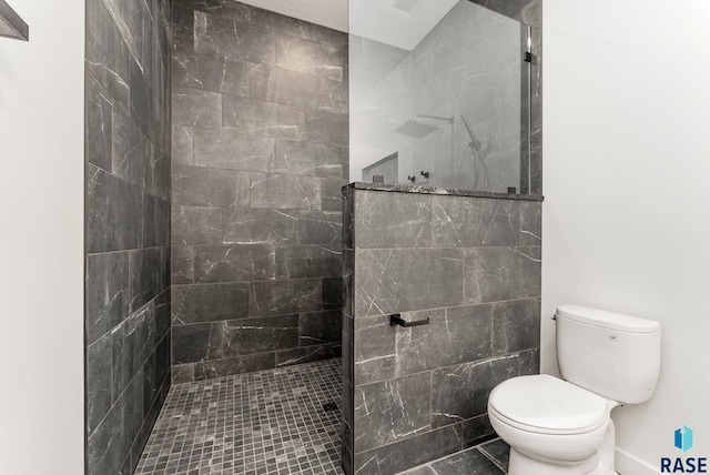 bathroom featuring tiled shower and toilet