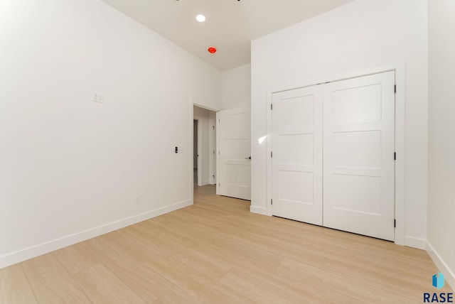 unfurnished bedroom with light hardwood / wood-style flooring and a closet