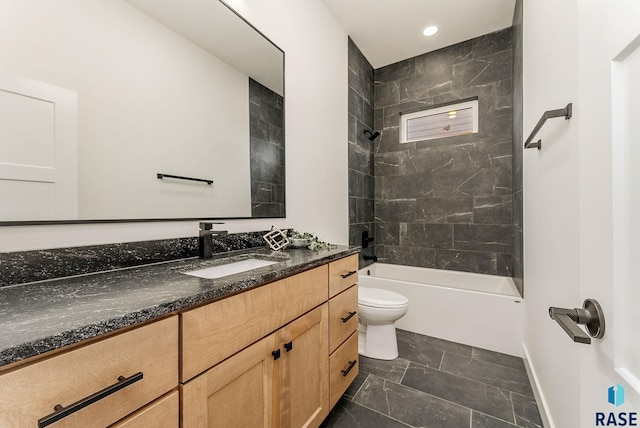 full bathroom featuring tiled shower / bath, vanity, and toilet