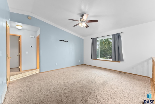 empty room with lofted ceiling, carpet flooring, and ceiling fan