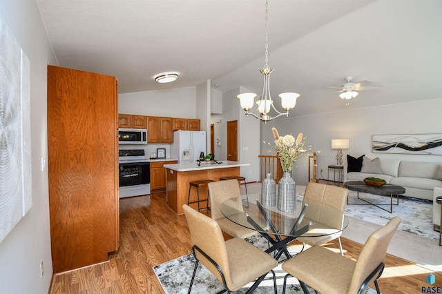 dining space featuring light hardwood / wood-style flooring, a chandelier, and vaulted ceiling