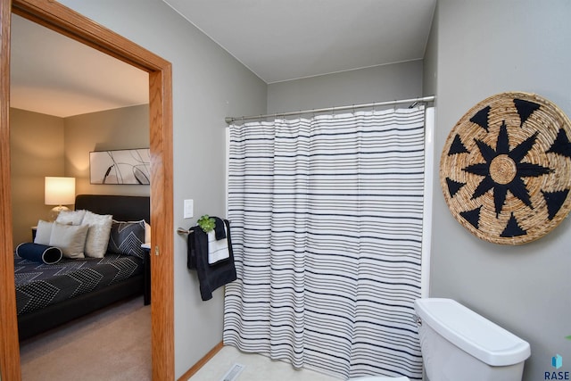 bathroom featuring curtained shower and toilet