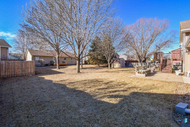 view of yard featuring a storage shed, a deck, and a patio area