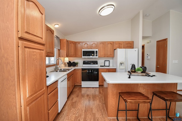 kitchen featuring white appliances, lofted ceiling, a center island, and sink