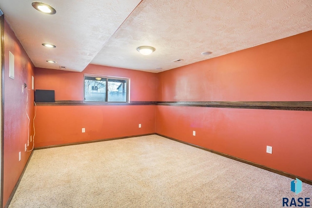 empty room with light carpet and a textured ceiling