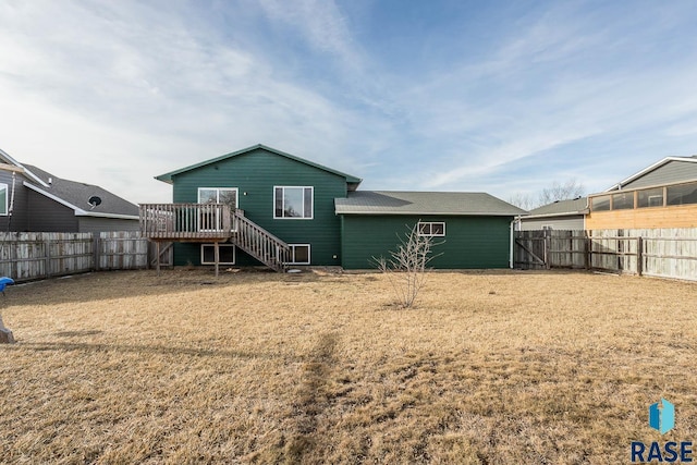 rear view of house featuring a wooden deck and a yard