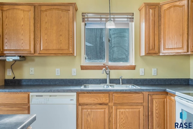 kitchen with white dishwasher, decorative light fixtures, and sink