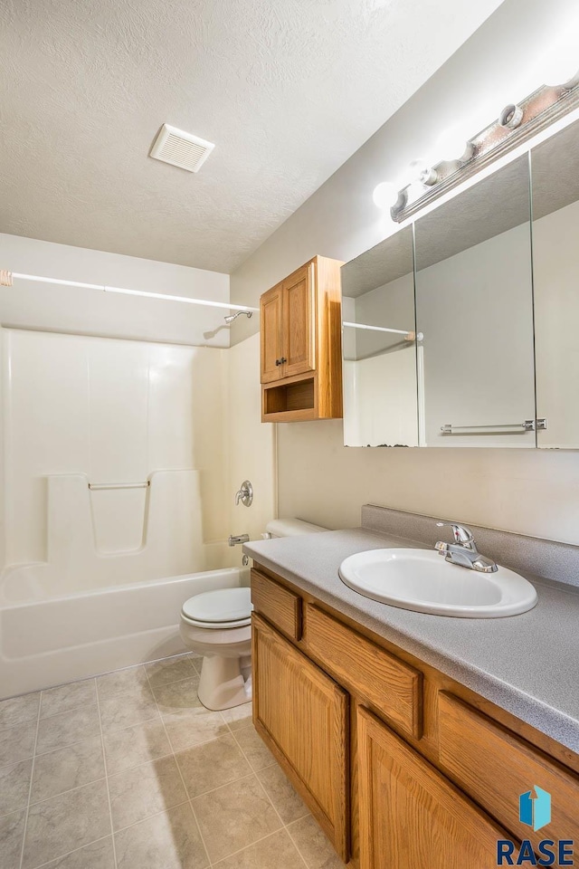 full bathroom featuring toilet, a textured ceiling, shower / bathtub combination, vanity, and tile patterned flooring